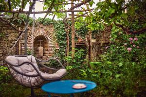 una silla y una mesa en un jardín en Le Couvent, en LʼHermenault