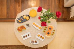 a table with food on top of it with roses at Palace Museum & National Monument - Espaço Palmeiras in Porto