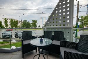 a patio with a table and chairs on a balcony at Red Luxury Apartment Lake On in Mamaia