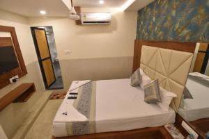 - une chambre avec un lit et une télévision dans l'établissement Hotel Dream Palace Residency - Near US Consulate, BKC LBS Marg, à Mumbai