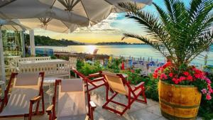 een patio met stoelen en een tafel met een potplant bij Aphrodite Beach Hotel in Nesebar