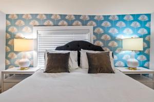um quarto com uma cama branca e 2 candeeiros em Casa Lovett - Tropical Bungalow em St. Augustine