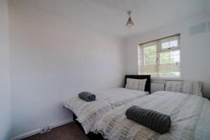 twee bedden in een kamer met witte muren bij Cheerful 3 Bedroom Family Home with parking in Leicester