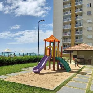 a playground in front of a building with a slide at Mar com Diversão in Barra Velha