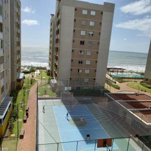 a tennis court with a net in front of a building at Mar com Diversão in Barra Velha +4 photos