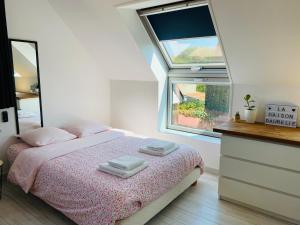 um quarto com uma cama com duas toalhas em La maison d’Aurélie em Pleudihen