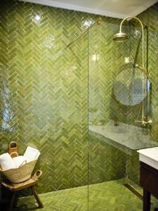 a bathroom with a glass shower with a chair at Dar Jasmine in Chefchaouene