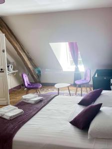 a bedroom with a large bed with purple chairs at Room in Guest room - Les Chambres De Vilmorais - Violette Prince 