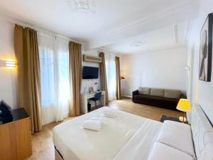 ein Schlafzimmer mit einem großen weißen Bett und einem Sofa in der Unterkunft Flor Habitaciones in Barcelona