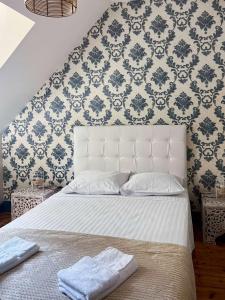 a bedroom with a white bed with blue and white wallpaper at Room in Guest room - Vilmorais Rooms 