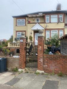 una casa con una puerta y una valla de ladrillo en Big Home in London, Forest Hill en Londres