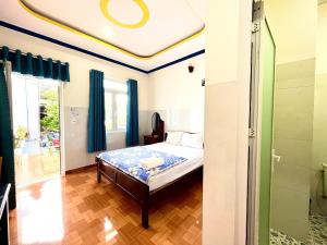 a bedroom with a bed with blue curtains and a ceiling at Minh Khoi Guest House in Mui Ne