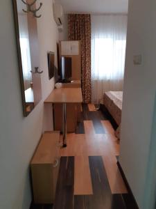 a small room with a bed and a desk and a television at Hotel Mya in Bistriţa