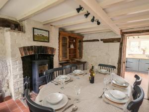 a dining room with a table and chairs and a fireplace at Groveside in Hereford