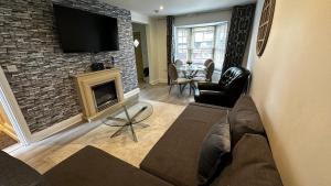 a living room with a fireplace and a tv on a brick wall at One Bedroom Flat Town Centre Colchester in Colchester