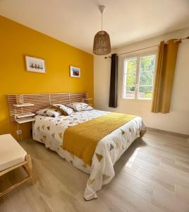 勒沙托多莱龙LA CASA DE BABOU的卧室里有一张床和一面黄色的墙