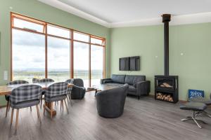 sala de estar con mesa, sillas y chimenea en 4bed 4bath Sauna & Hot tub en Reykholt