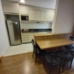 a kitchen with a wooden table and a refrigerator at Mar com Diversão in Barra Velha