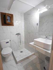 bagno bianco con lavandino e servizi igienici di Aiora View a Theológos