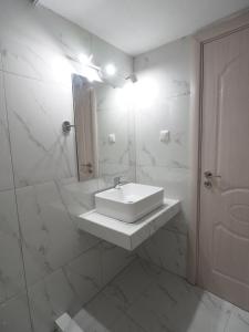 bagno bianco con lavandino e doccia di Aiora View a Theológos
