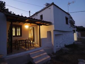 a small white house with a table and chairs at Aiora View in Theologos