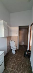a bathroom with a toilet and a tiled floor at MatyiLak in Tîrgu Secuiesc