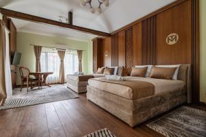 a bedroom with a large bed and a chair and a table at Casa MT - Boutique Villa in Gabrovo