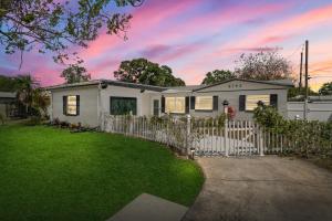 a white fence in front of a house at Perfect Pool & Hot Tub Retreat in Pinellas Park