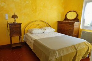 - une chambre avec un lit, une commode et un miroir dans l'établissement Mas Dante, à Cassis