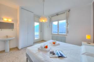 a white bedroom with a white bed and a sink at Villa Panorama with private pool - Happy Rentals in Nago-Torbole