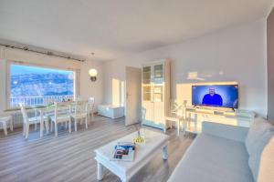 a living room with a couch and a tv and a table at Villa Panorama with private pool - Happy Rentals in Nago-Torbole