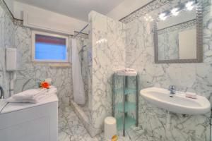 a white bathroom with a sink and a mirror at Villa Panorama with private pool - Happy Rentals in Nago-Torbole +34 photos