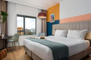 a hotel room with a bed and a desk and a window at Neighbourgood Newlands in Cape Town