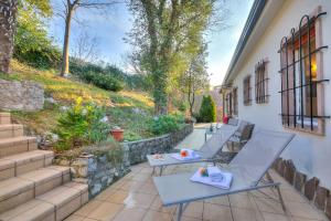 una fila di tavoli su un patio di Villa Panorama with private pool - Happy Rentals a Torbole