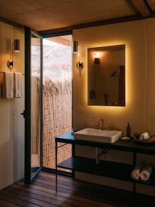 a bathroom with a sink and a mirror at Our Habitas AlUla in Al-ʿUla