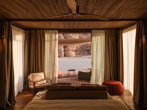 a bedroom with a bed and a chair and a window at Our Habitas AlUla in AlUla +53 photos