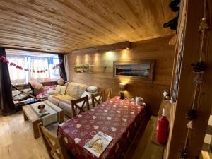 a living room with a table and a couch and a room with a tableablish at SUPERBE 2 P et CABINE , Plein sud, 8 COUCHAGES STYLE CHALET in Val Thorens
