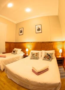 um quarto de hotel com duas camas e duas lâmpadas em Hotel Albatros em Punta Arenas