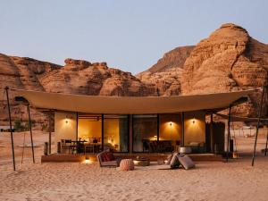 a house in the desert with a mountain in the background at Our Habitas AlUla in AlUla