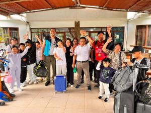 um grupo de pessoas com as mãos no ar em Natura Gardens Galápagos em Bellavista