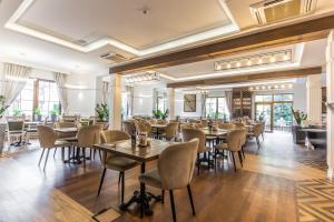 Hotel Wisła Premium في فيسلا: مطعم فيه طاولات وكراسي في الغرفة