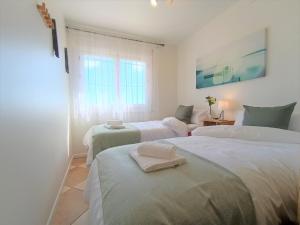 1 dormitorio con 2 camas y ventana en Villa del Sol, en Benalmádena