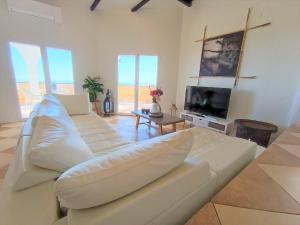 a living room with a white couch and a tv at Villa del Sol in Benalmádena
