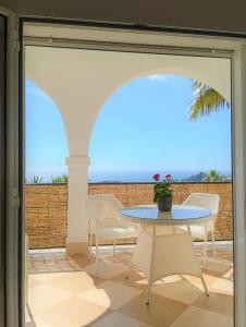 una puerta de cristal que da a un patio con mesa y sillas en Villa del Sol, en Benalmádena