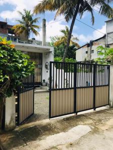 a black gate in front of a house at Roshan Villa in Weligama