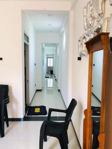 a black chair in a room with a hallway at Roshan Villa in Weligama