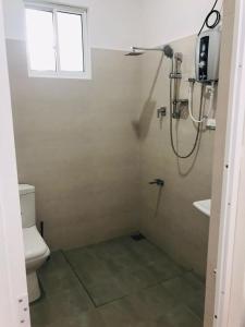 baño con ducha, aseo y ventana en Roshan Villa en Weligama
