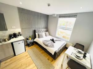 a small bedroom with a bed and a kitchen at Studios next to Emirates Stadium in London