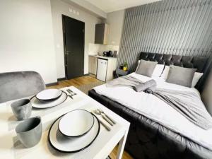 ein Schlafzimmer mit einem Bett und einem Tisch mit Tellern darauf in der Unterkunft Studios next to Emirates Stadium in London