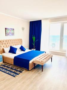 1 dormitorio con 1 cama grande con sábanas azules y almohadas azules en KIR House On The Beach en Eforie Nord